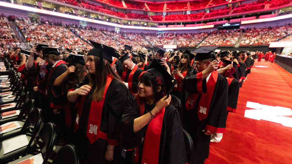 Students flip tassels on caps during undergraduate commencement