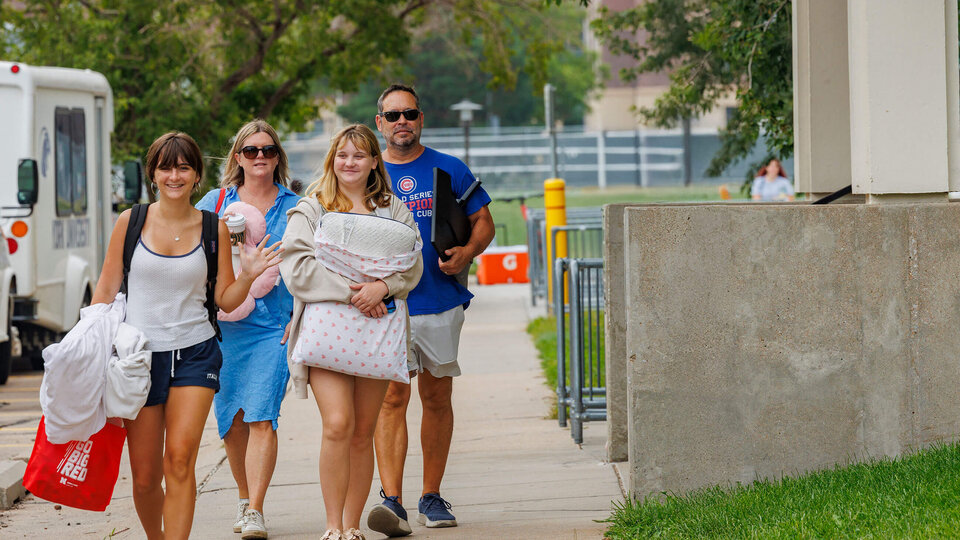 Student walks with parents during move-in 