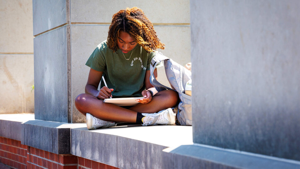 Student sitting in common space behind Nebraska Union