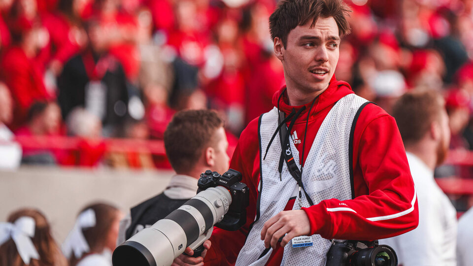 Student holding camera while in Memorial Stadium
