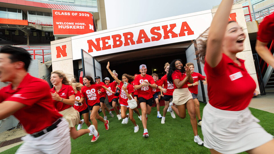 Students run out of tunnel at Memorial Stadium as part of Big Red Welcome