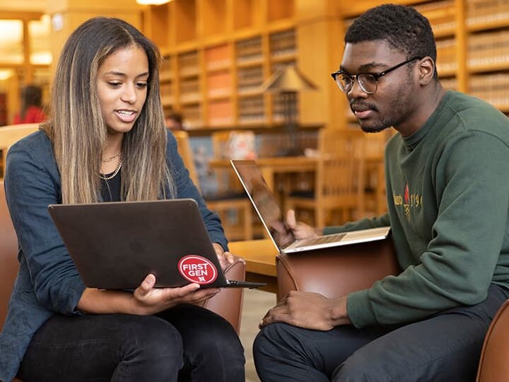Two students compare laptop notes in the Schmid Law Library