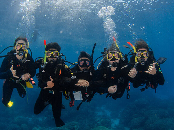 Students in scuba gear underwater off the coast of Australia