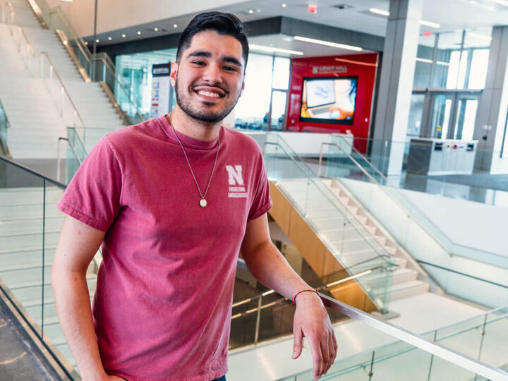 Student leaning on railing in Kiewit Hall