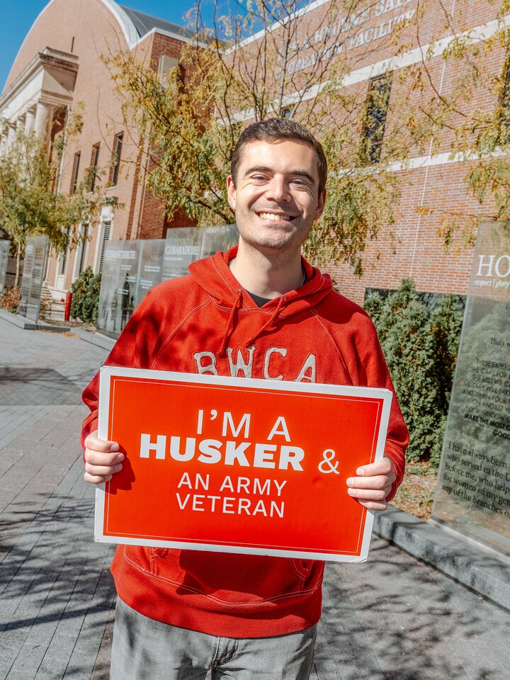 Brett holding the I'm a Husker & sign. 