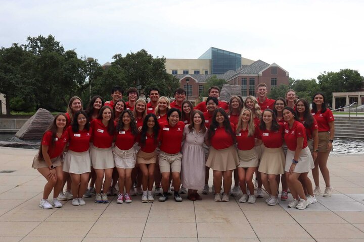 Jenny Castor and other members of the orientation leaders group for new student enrollment stand in front of the Broyhill fountain.