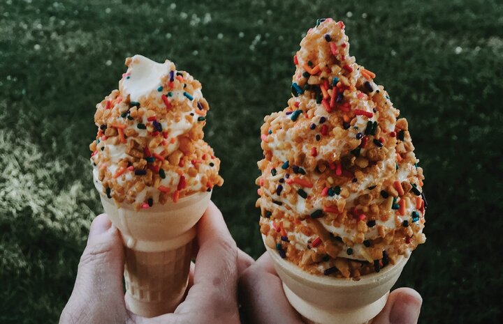 Two cones of vanilla soft serve with a crunch coating