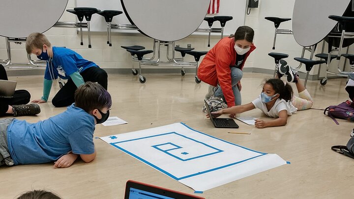 Arnold Elementary students working on coding activities alongside Huskers in the Initialize UNL RSO.
