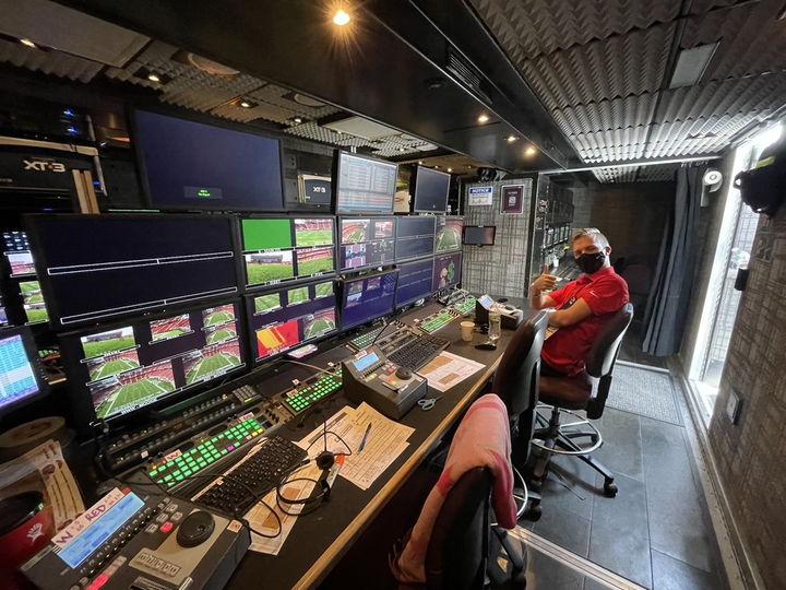 Aaron gives a thumbs up from the booth, examining dozens of camera angles