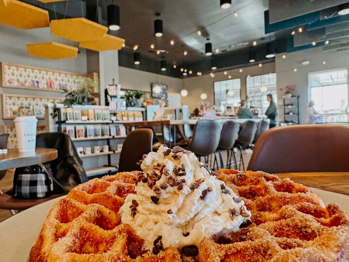 A waffle topped with whipped cream and chocolate shavings