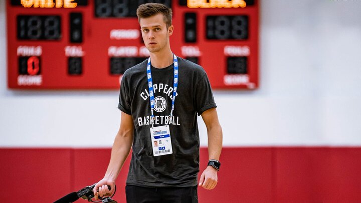 Sam Rice walks on the Clippers court with a video camera during his internship