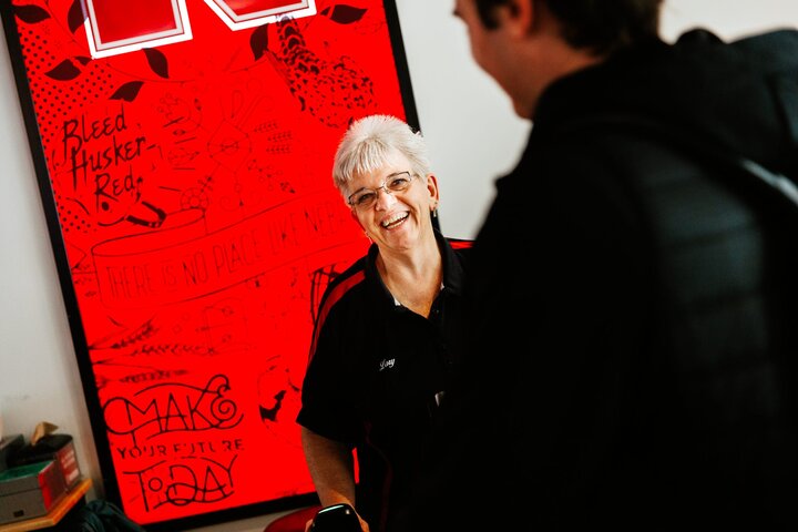 Lory laughs with a student while checking them in