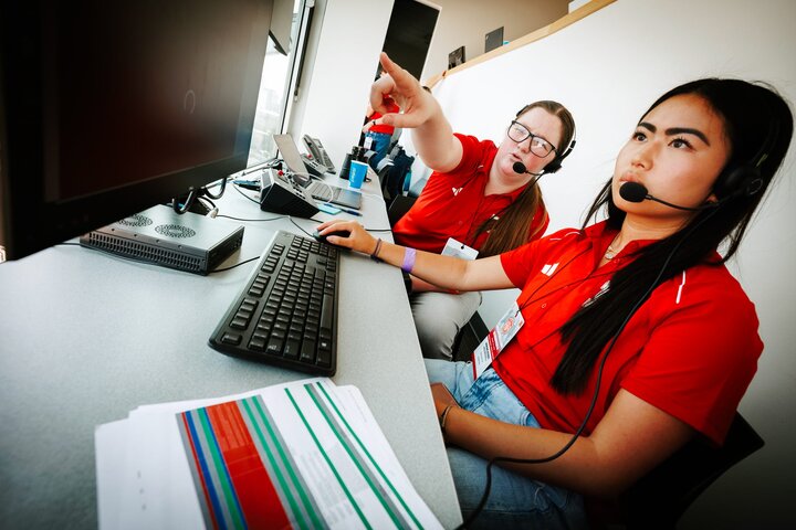 Melanie points to the screen as she works with a colleague during Volleyball Day in Nebraska