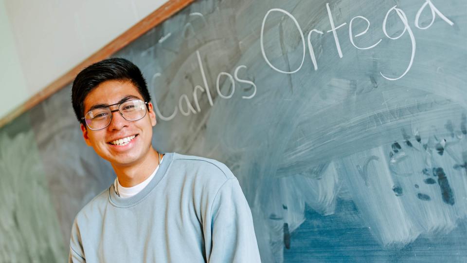 Student standing in front of chalkboard