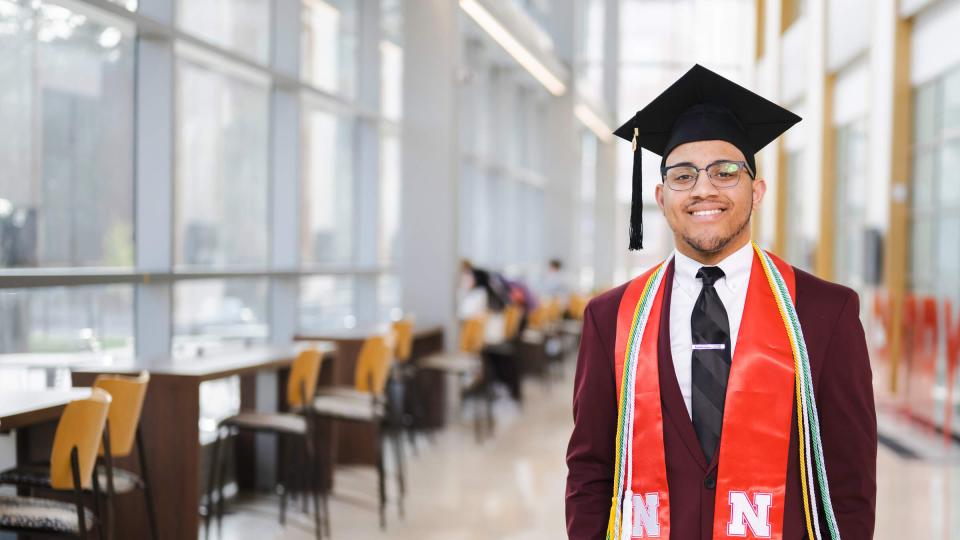 Student wearing cap and gown inside College of Business