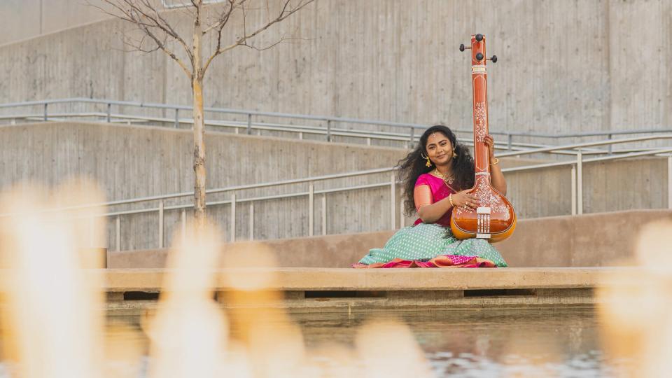 Student sitting behind fountain with sitar