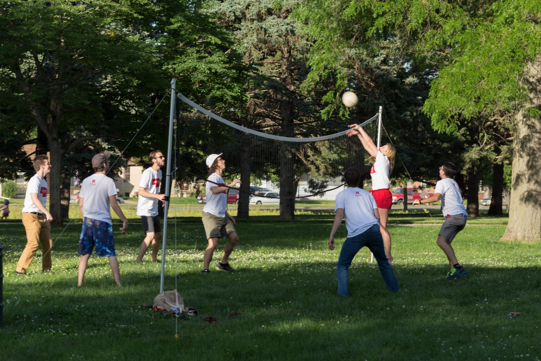 Students playing volleyball at picnic.