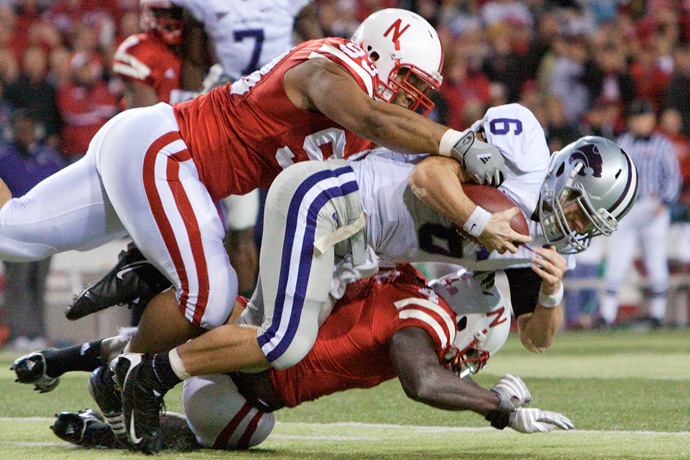 Football players tackling during a game at Memorial Stadium